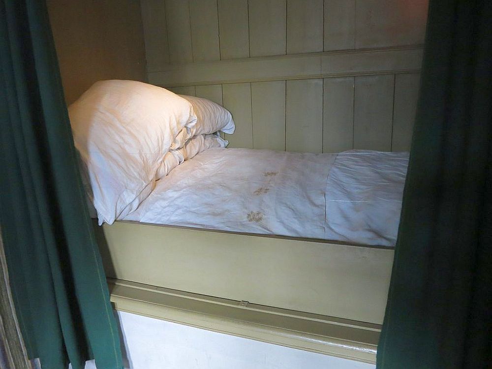 Inside Ons Lieve Heer op Solder: A bedstee is a bed built into the wall, in this case with curtains rather than doors to close it.