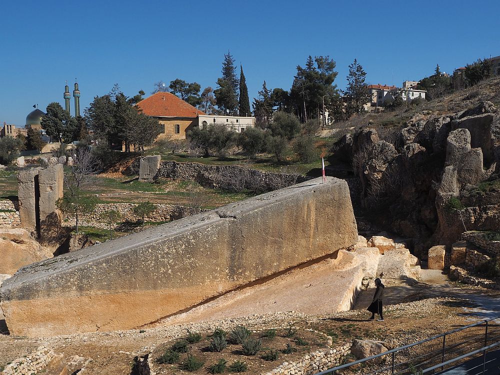 The 1000 ton stone is a long rectangular shape, tilted upward at the uphill end. The woman doesn't even reach the bottom of the stone -- Roman Quarry near Baalbek