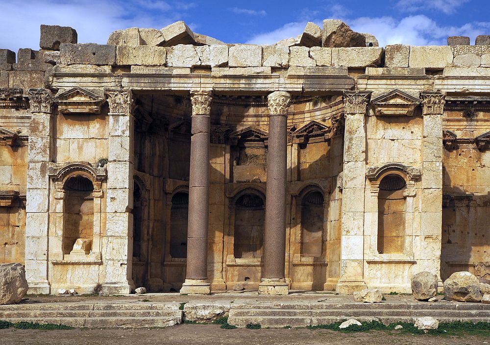 This side altar is probably about 3 stories tall, with two pink granite Corinthian columns holding the pediment up and empty statue niches beside and behind the columns.