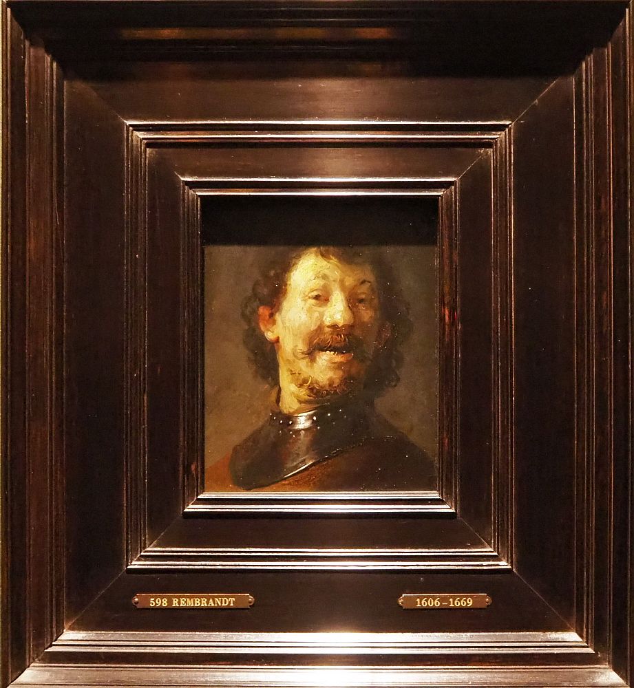 This picture is just what it says,: a laughing man. He's almost directly facing the viewer, lighted from one side. Brown curly hair and scruffy beard.  Den Haag museum Mauritshuis