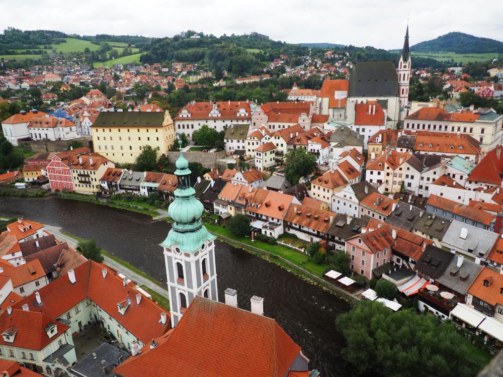 A view over the town from Cesky Krumlov castle: lots of pastel buildings with red roofs.