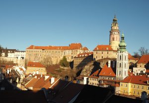 The castle extends across the whole photo, with a large blockish building on the left and a round tower on the right.