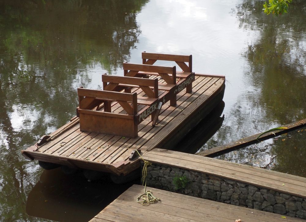 A simple wooden rectangle maybe a foot off from the surface of the water, with 4 2-person benches one in front of the other. A flat space at the back for the polesman to stand.