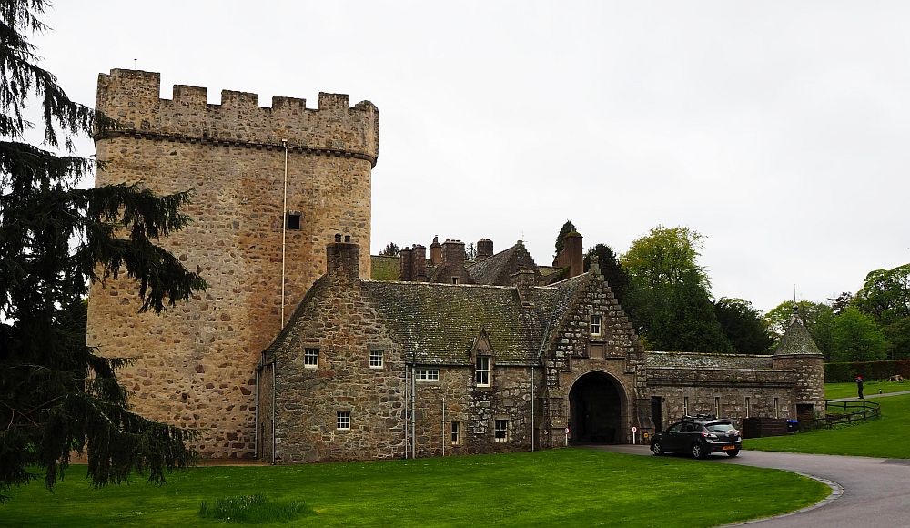 Drum Castle, is mostly low stone construction, with one squat tower on the left of the picture, crenellated at the top.