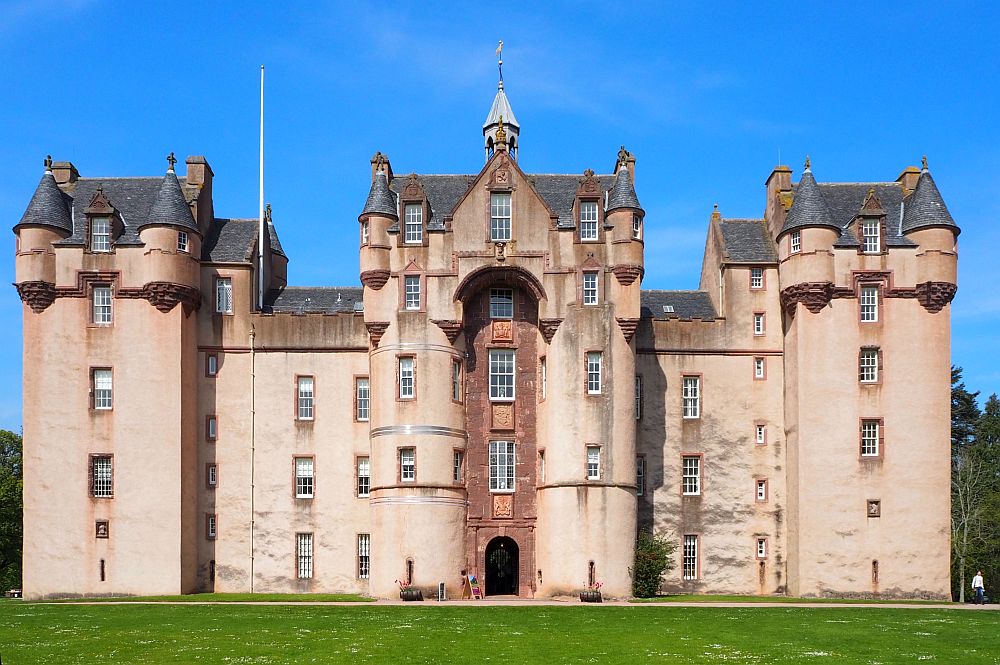 A massive, imposing castle with a huge archway over the front door and massive towers on both sides.