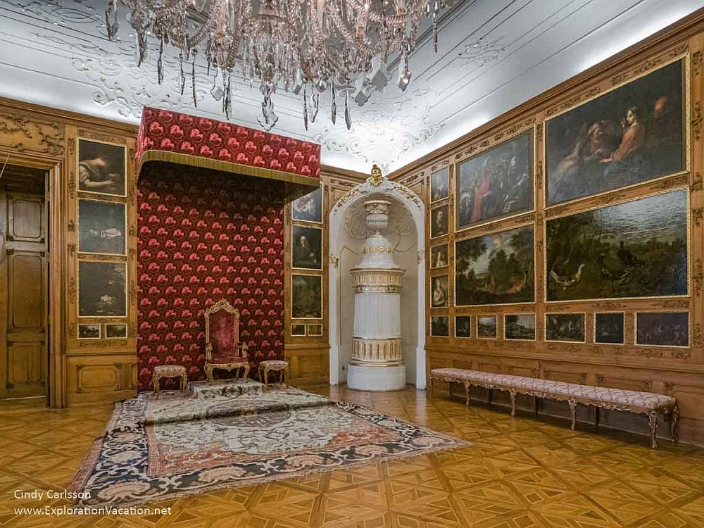 A throne on a raised platform on the far wall, with the side walls and ceiling ornately painted.