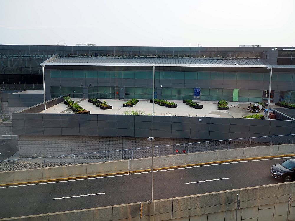 The side of Terminal 5 is visible, with a road passing in front of it. It seems to have some sort of garden boxes under a glass roof.