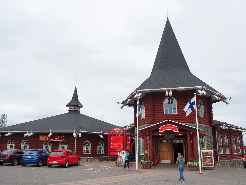 The right-hand building has a two-story, round entrance, with a tall peaked roof. It's painted dark red. The one on the right is lower and flatter, also red, and also with a small turret on the roof. 