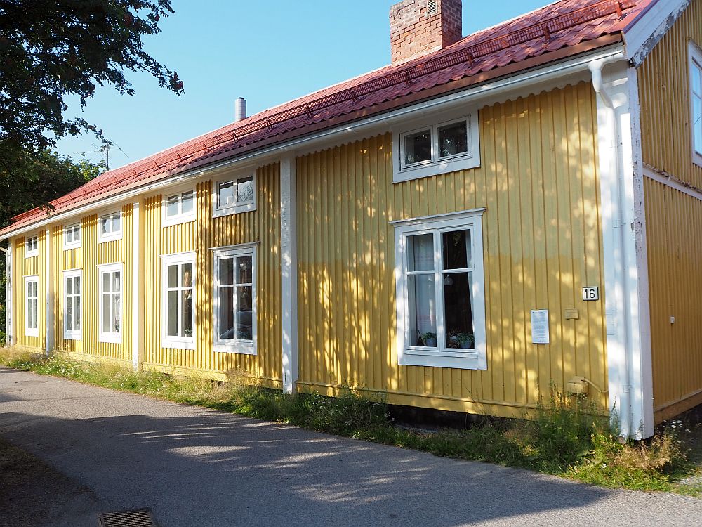 This burgher's house in Gammelstad church town is, unlike most, painted yellow, with white trim around the windows and no shutters. It's two stories tall, with tall windows below and smaller, horizontal windows above.