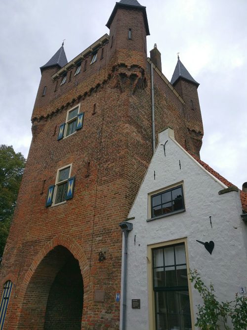 The gate has an arched opening at its base and turrets on top on each of its 4 corners.