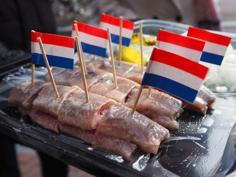 small chunks of fish, most with small Dutch flags on toothpicks sticking up out of them.