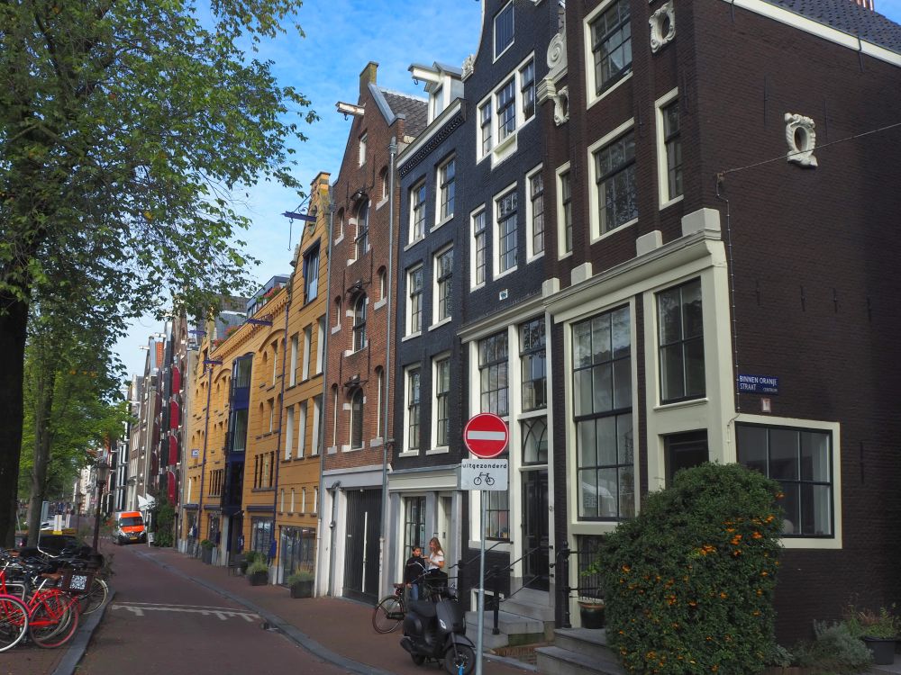 Looking down a row of typical Amsterdam rowhouses: brick with white windows, which we passed on the Jordaan food tour.