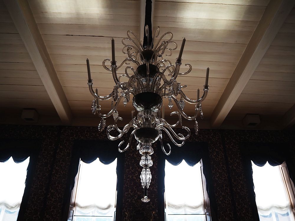 This chandelier is particularly elegant: just arms of crystal in several tiers that curl down and then up. Some of them hold candles. Some of them have a single hanging ornament of crystal. 