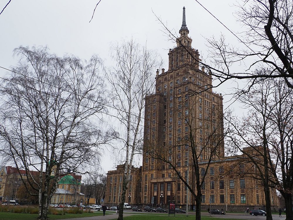 The building is a very large square shaped spire. Blockish for most of its height, then with several levels that are also square, but smaller, tiered like a wedding cake. The top has a pointed spire. 