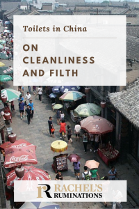 Pinnable image Text: Toilets in China: On cleanliness and filth Image: a view from above of a street lined with simple brown brick buildings. Umbrellas cover street stalls on both sides of the street and people walk down the middle between them.
