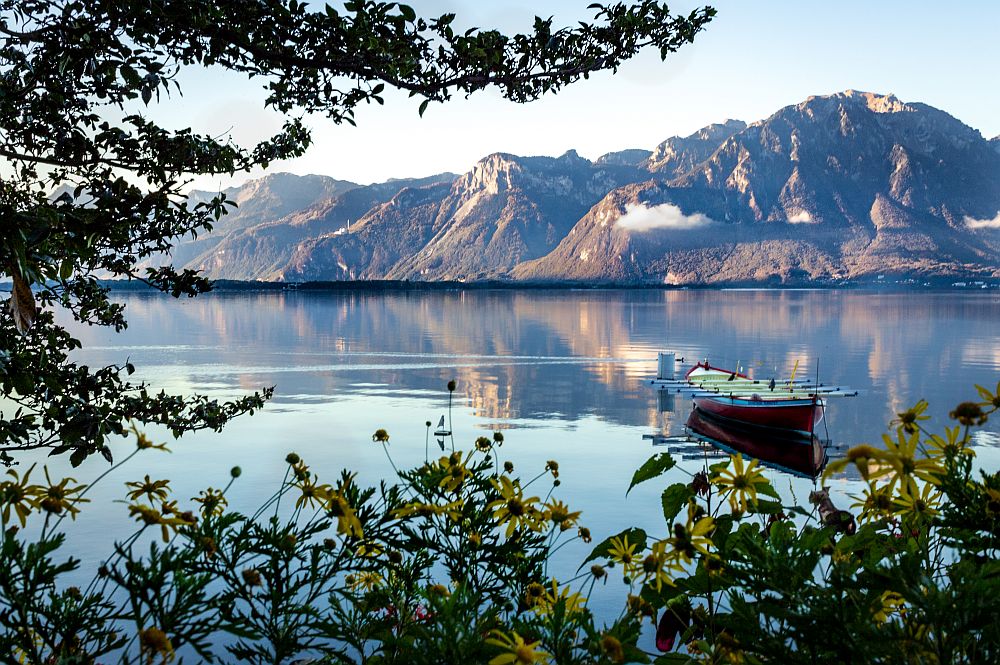 scenic view of a row boat on a lake with mountain background