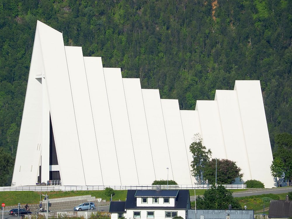 The cathedral, seen almost from the side, seems to be made of a series of triangles of different sizes, all bright white. The tallest is on the left, which seems to be the entrance. In 8 triangular sections, the height progressively decreases. The ninth , tenth and eleventh (the last piece) increase again in height.