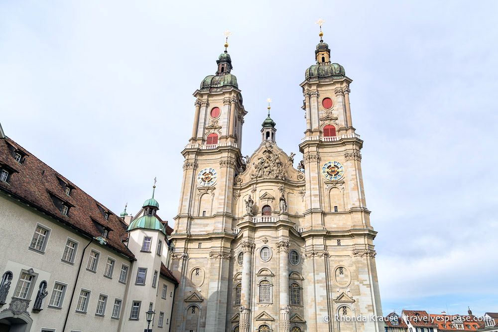 The front view of the Abbey of St Gall, white stone, ornate gables and with two spires. One of the UNESCO sites in Switzerland