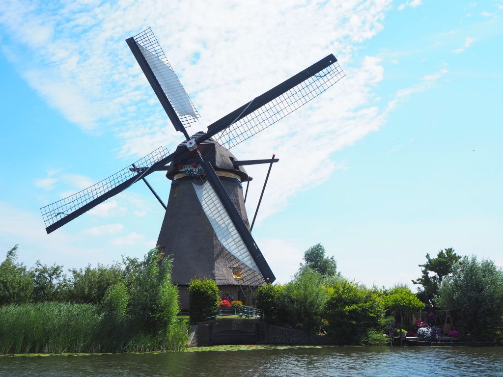 A closer view of one of the thatched octagonal windmills. there are 4 vanes, but only two have the sails unfurled over the vane to catch the wind.