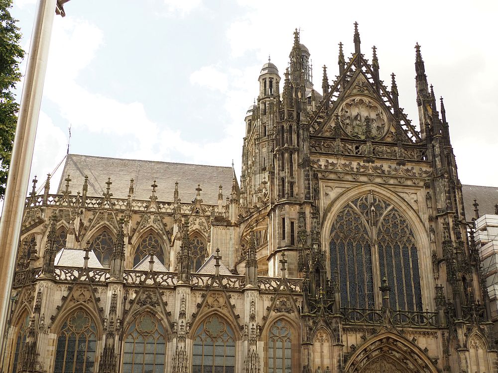 A gothic building: gothic arches with decorative crosses above them, a taller tower section with huge gothic arches and lots of turrets.