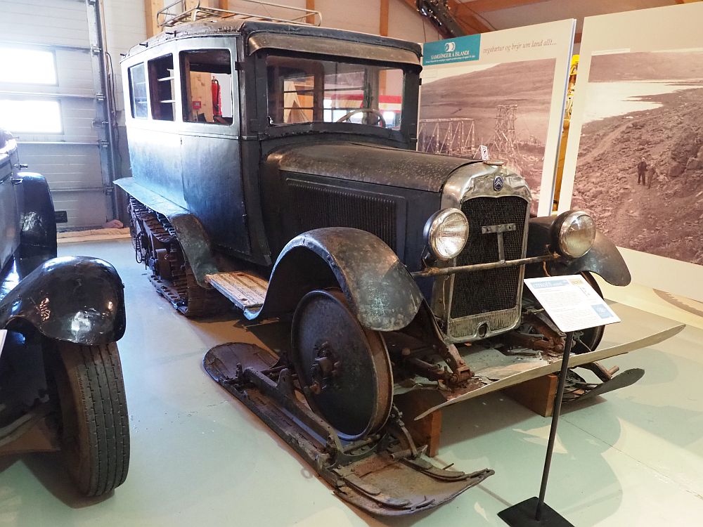 This looks like a normal 1930s car, with a big square body and the engine sticking out in front. However, instead of back wheels it has treads like a tank. Instead of front wheels, it has just the axle, attached to what look like wide, short skis.