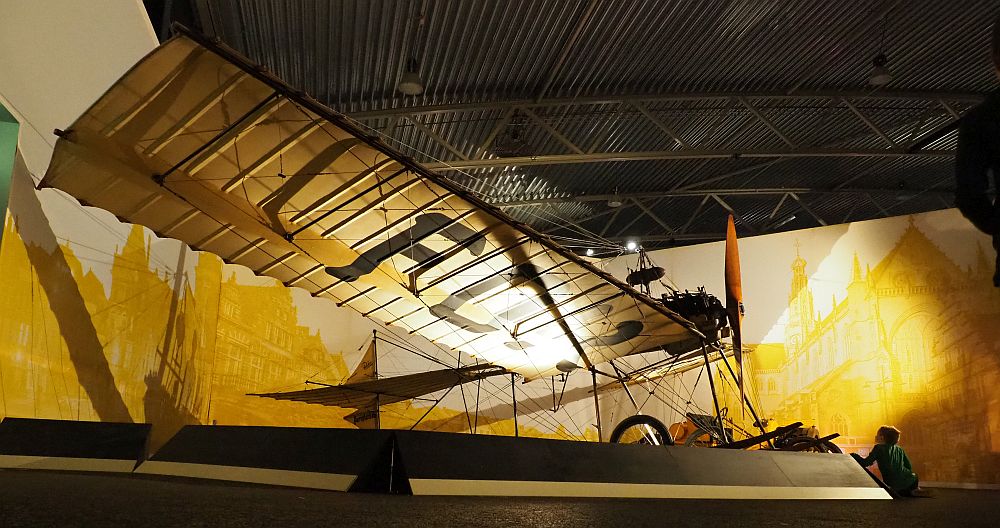 A very fragile-looking plain. Only the near wing is visible. It has a rod on the forward edge and ribs extending straight back from that. Canvas or some other material covers the ribbing. It has a single propeller on the front and a skeletal body. It resembles a dragonfly more than anything else.