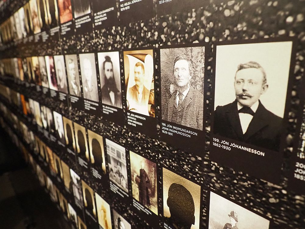 A wall covered with photos, all lighted up from behind. the nearest one says 199. Jon Hohannesson 1862