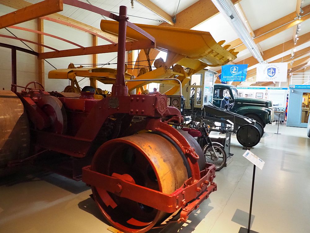 the nearest vehicle in the photo looks like it's an early steamroller. Behond that is an early bulldozer and other vehicles that are hard to identify.