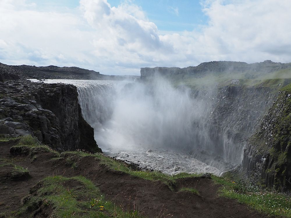 The wide waterfall and the canyon it cuts through, cliffs on both sides. The waterfall itself is hard to see with all the mist it churns into the air.