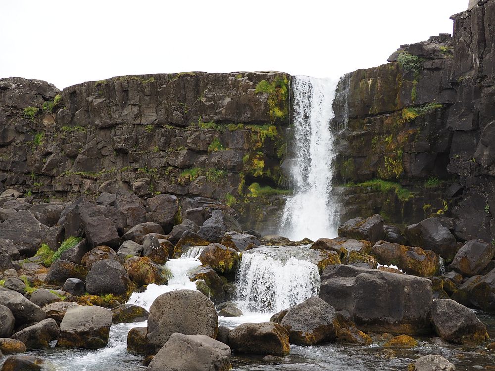 Not very wide, the waterfall falls from a cliff that looks like it was made from basalt buiding blocks.