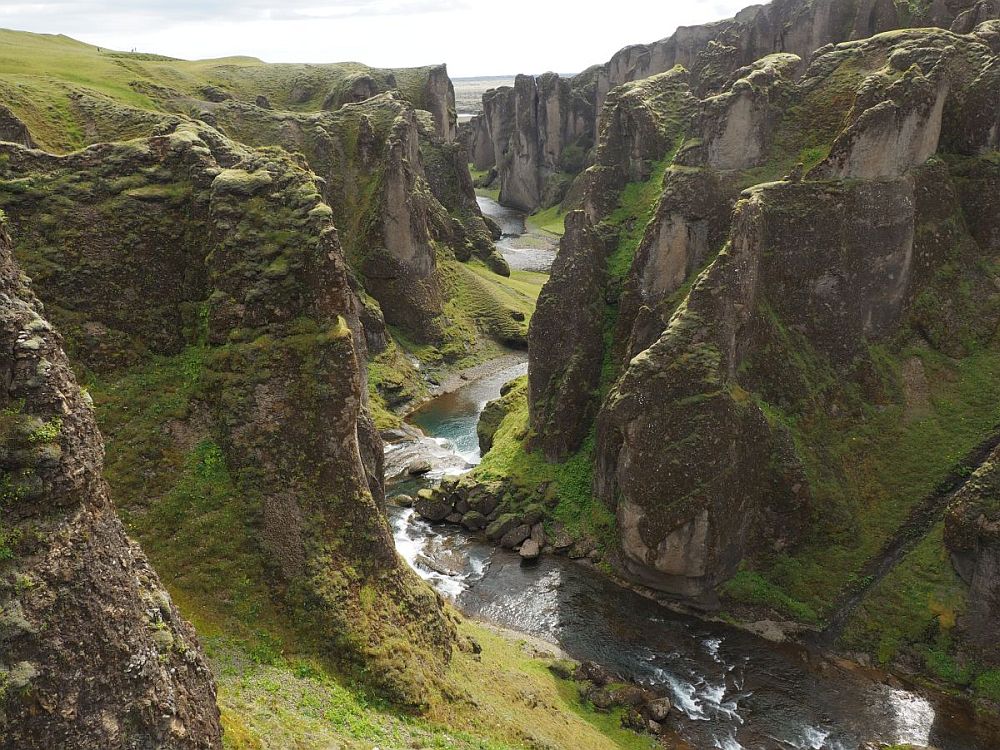 Looking down the length of the canyon: sheer rocky cliffs on either side frame a river that snakes between them.