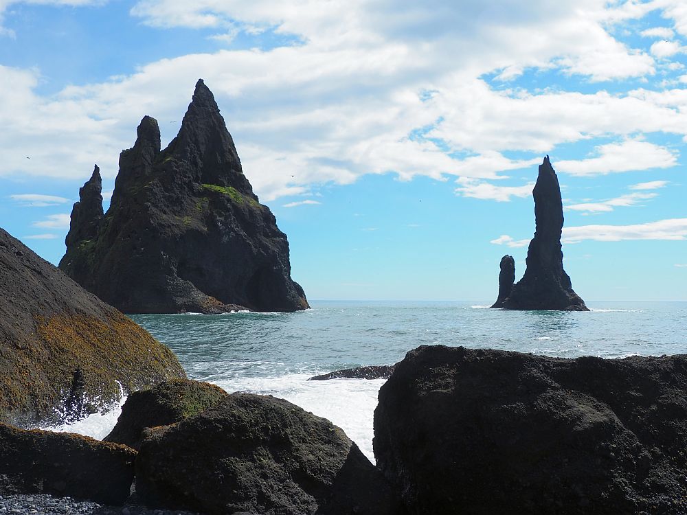 Two rock formations not far off the shore: The left-hand one is bigger and has three points; the right hand one is narrower and has one big point and one smaller one at the side. 