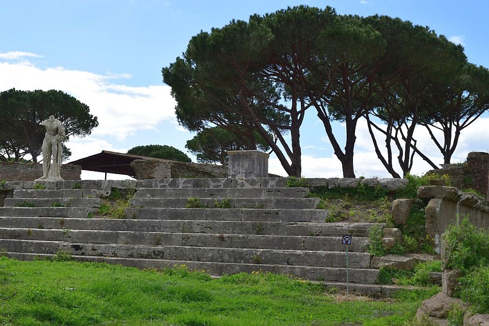 Steps up to the temple, but the temple is mostly gone. One statue of a male figure, missing its head.