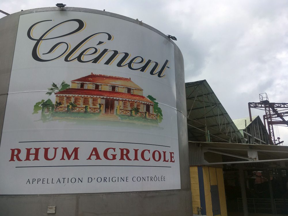 A large round tank with a sign reading "Clement Rhum Agricole Appellation d'origine Controlee."