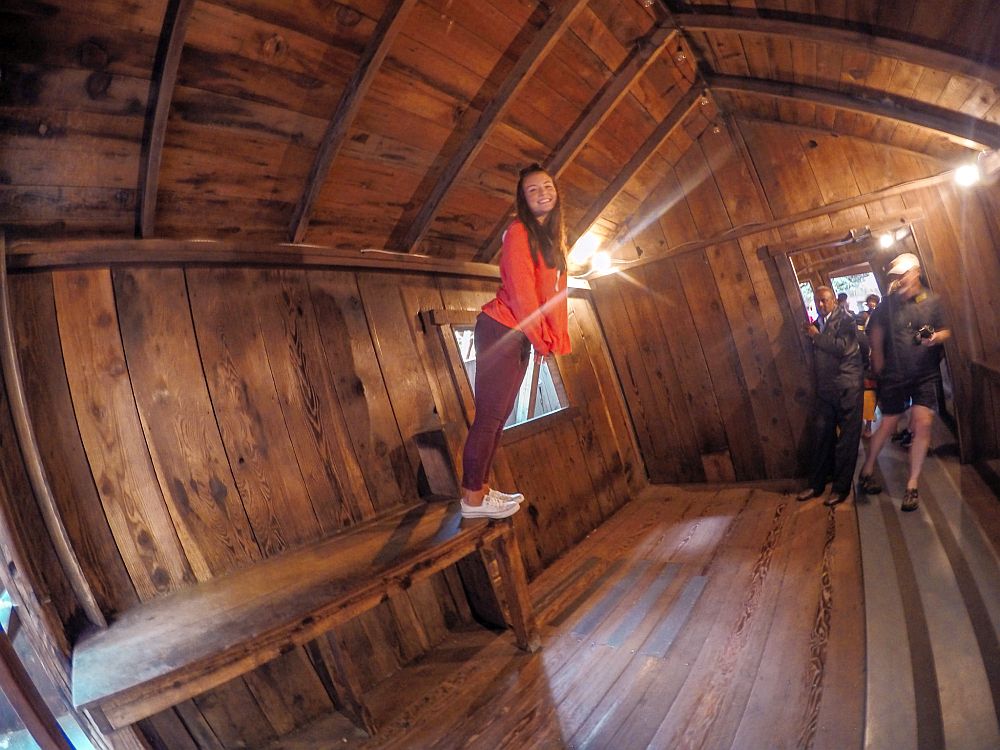 Inside a building in the Mystery Spot: the walls, floor and ceiling are all wood, but the people all seem to lean to the right, as if gravity isn't pulling them down but slightly to the left.