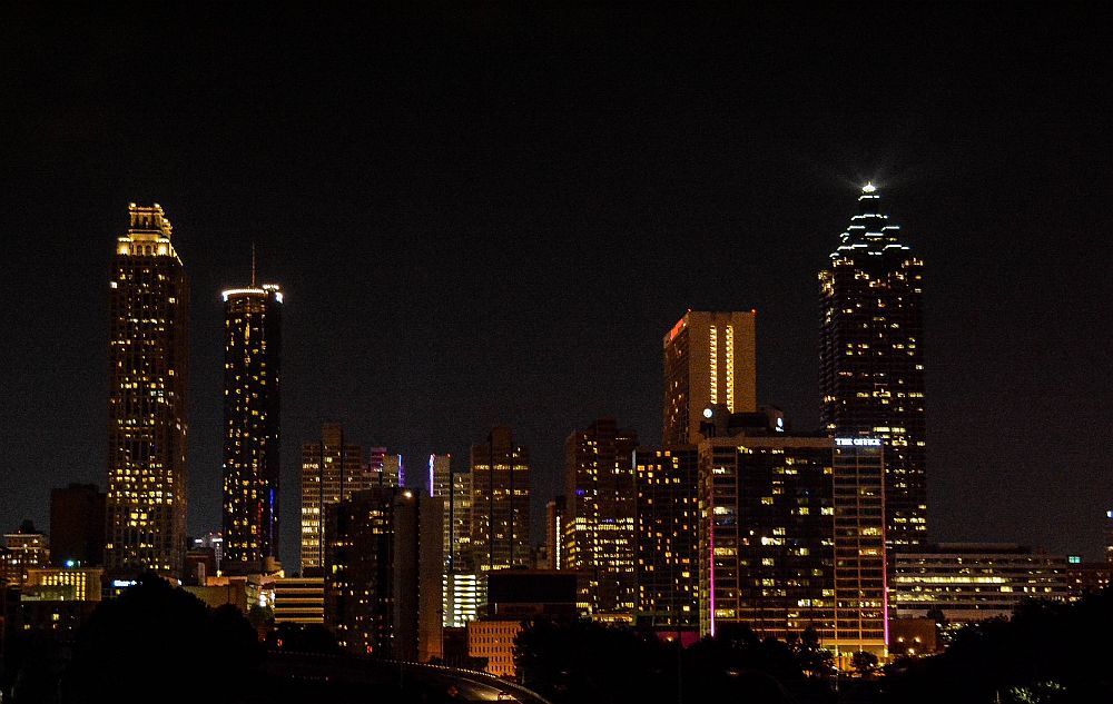 A nighttime view of the city: a jumble of tall buildings with lights in their windows. A weekend in Atlanta.