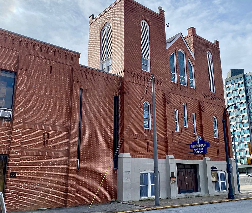 A view of the Ebenezer Baptist Church: a modest, 3-story brick building with arched windows edged in white paint. 