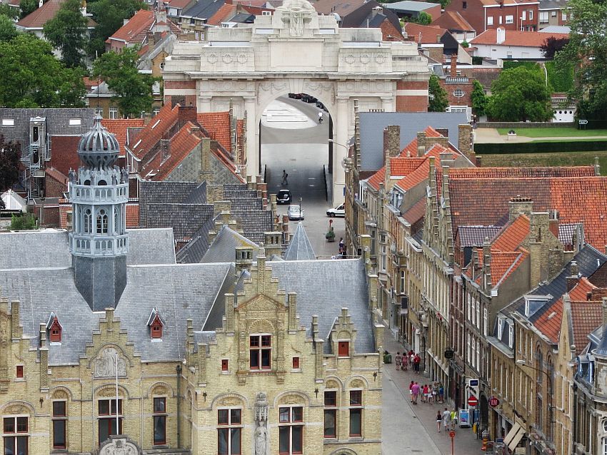 A view of Ypres from a tower. It shows a road with beautiful old buildings lining it, and a large arch over the road: the Menin Gate.