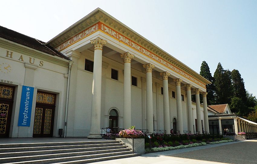 Seen from an angle, the building is long, but mostly only the center portion is visible. It has a square arcade in front of it, held up by a row of 8 pillars.