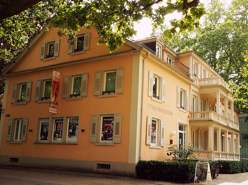 A compact villa in light orange: 3 stories, with small porches across part of the front.