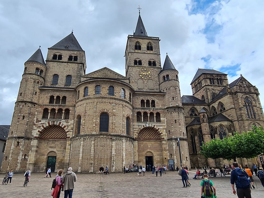 The left-hand church is asymmetrical, with a rounded shape in the middle and a tower on either side of it, each square with a pointed roof, and each a different height. The entrances are under each tower rather than in the center. On each corner is a smaller turret with a pointed roof. All of the arches - over the entrances and over each window - are Romanesque. The right-hand church has only one short square tower in the middle, but has more gothic lines in terms of the windows' arches.