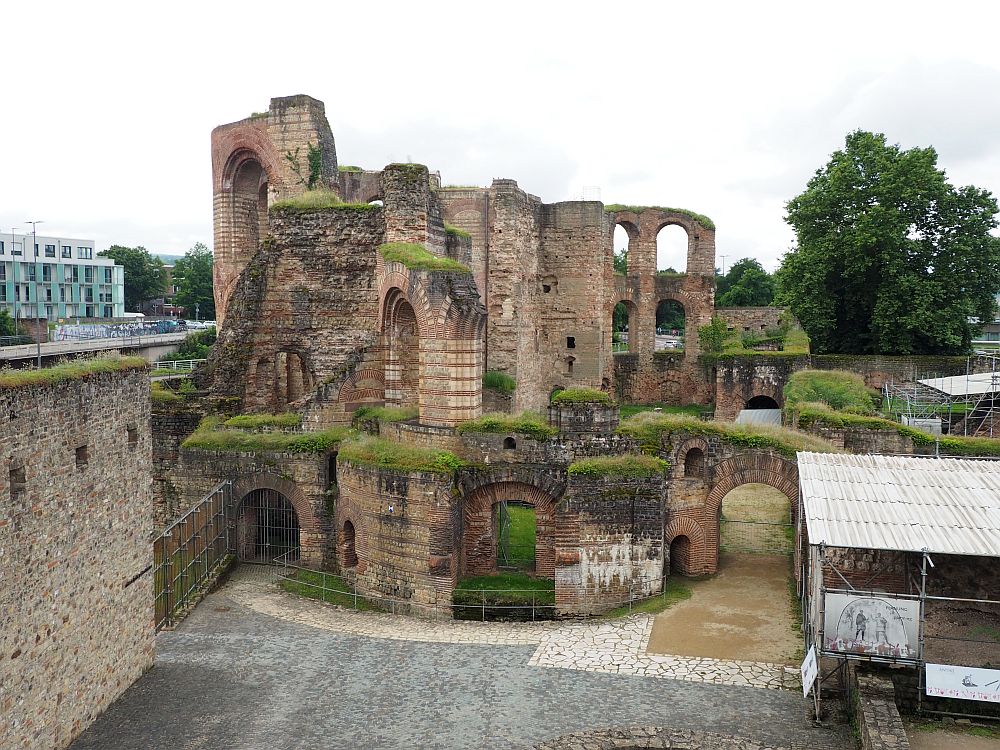 A jumble of ruin, mostly only the outer shells still standing: empty arched windows in curved walls that go about 3 storeys high in places. Weeds grow on the tops of the walls. 