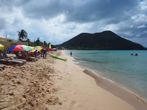 A view down Reduit Beach on St Lucia, with a mountain in the background.