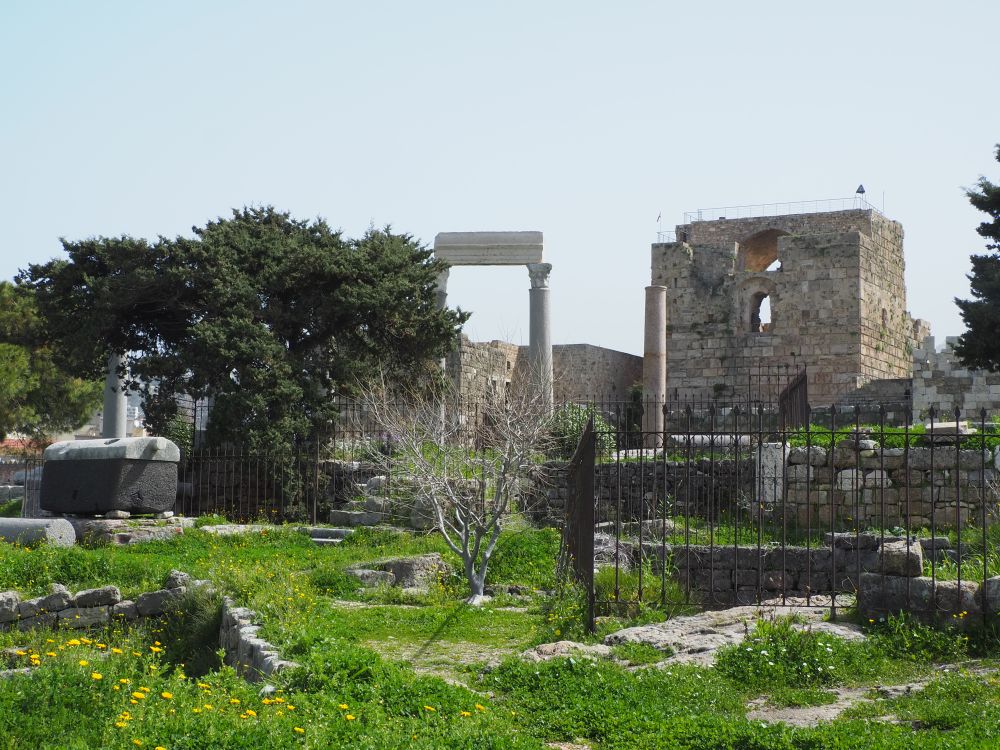 View of the citadel with columns in front of it and various ruins scattered.