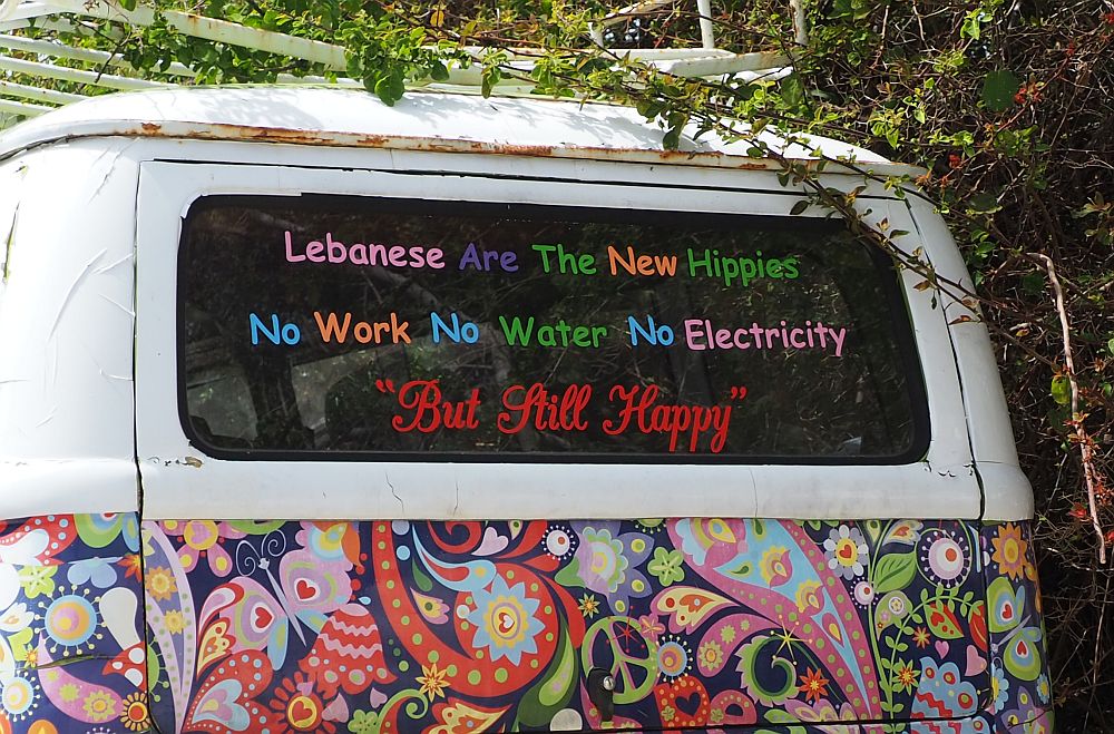 Lebanon travel tips: Back of a brightly painted van with the words "Lebanese Are The New Hippies / No Work No Water No electricity / But Still Happy"