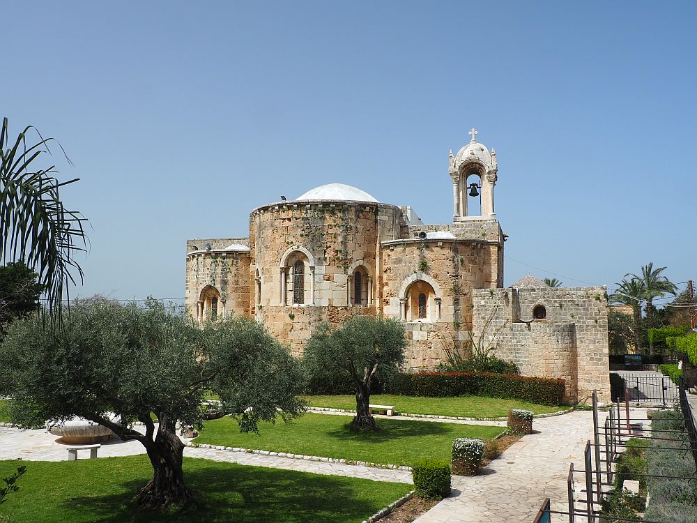 A stone church with rounded apses and a small open bell tower with a bell. 
Lebanon Travel Tips