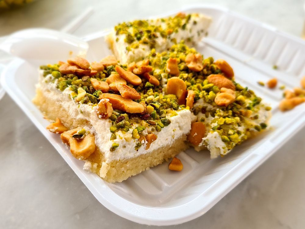 A Lebanese dessert: a cake or cookie base with a white cheesecake top, sprinkled with green ground pistachios and also peanuts.
Lebanon travel tips