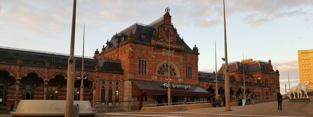 An elegant brick building with the word "Groningen" above the entrance.