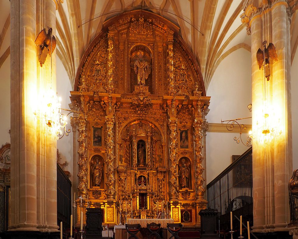 The altar fits into the arch of the ceiling against the back wall and is incredibly ornately carved over every inch, with niches holding equally ornate statues. All of it is covered in gold.