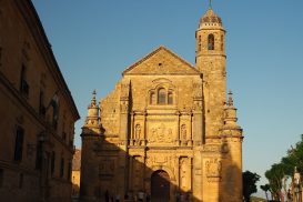 A view of the front of El Salvador Chapel in Ubeda, with detailed sculpture on the facade, and a tall tower.
